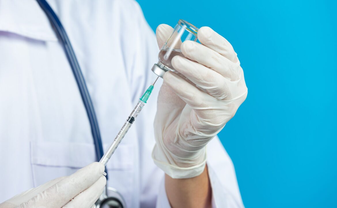 close up picture of docter's  hands holding hypodermic syringe