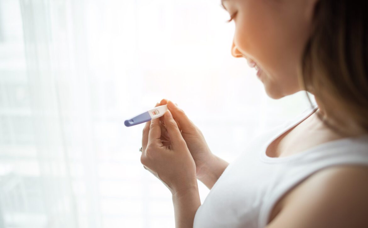 Young woman hand holding pregnancy test