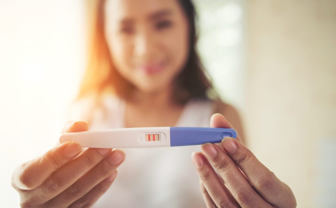 Young woman hand holding pregnancy test