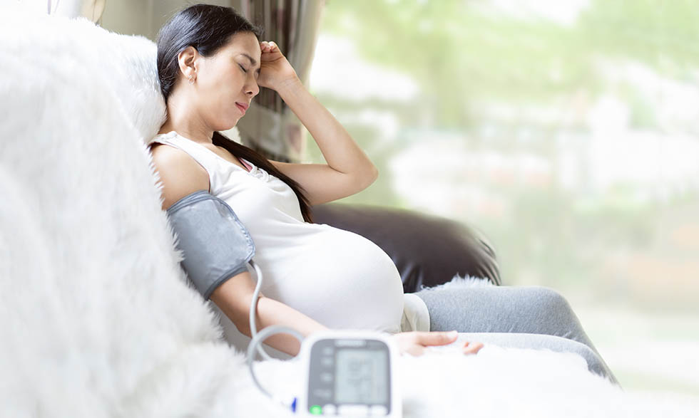 Asian pregnant woman is monitor blood pressure while she has hea